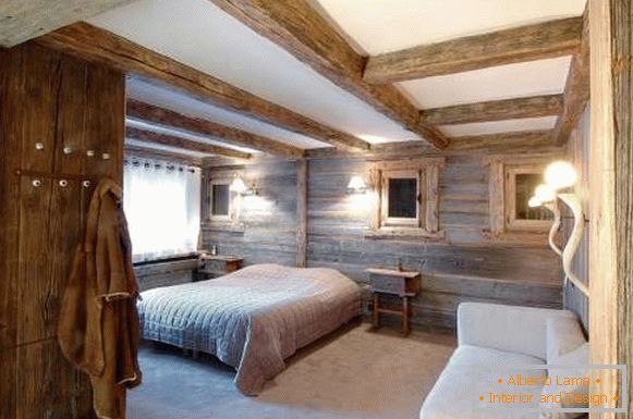 Interiorul unui dormitor într-o casă de țară, în stilul unei cabane