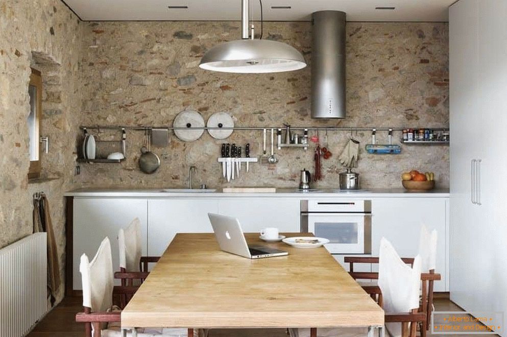 Bucătărie cu pereți din beton și un dulap mare cu zonă de luat masa