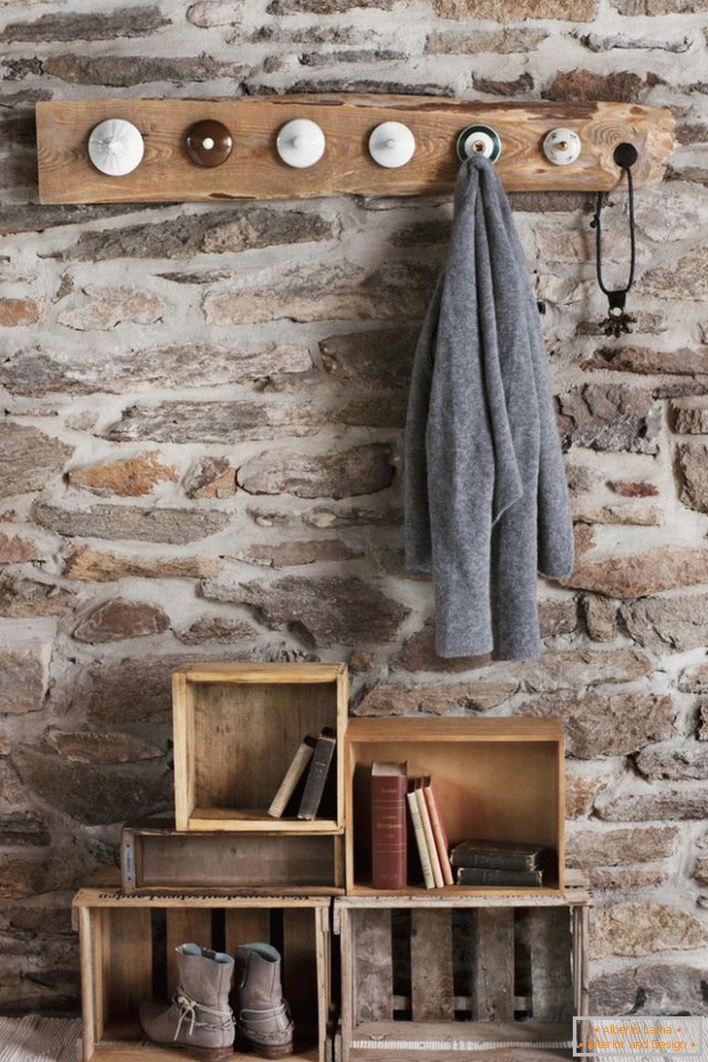 Dulap rustic DIY în cameră cu perete de piatră; cuișoare din hârtie din vechile china și cutii vechi de lemn pe podea ca depozitare