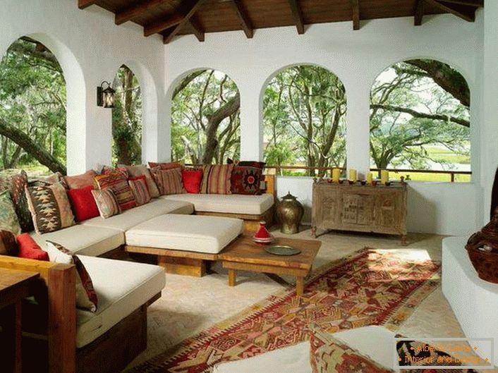 Veranda casei este decorată în stilul mediteranean. O caracteristică interesantă este decorul cu o mulțime de perne colorate.
