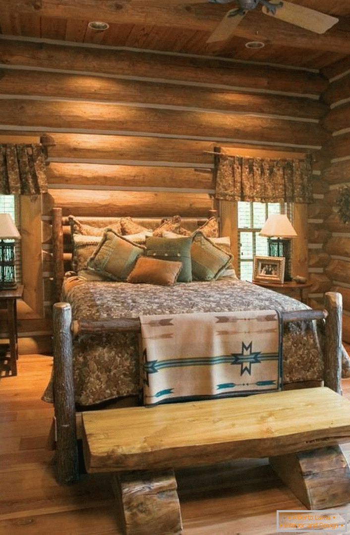 Un exemplu clasic de dormitor în stil rustic. Pat interesant dintr-o casă de busteni brut și netratată. 