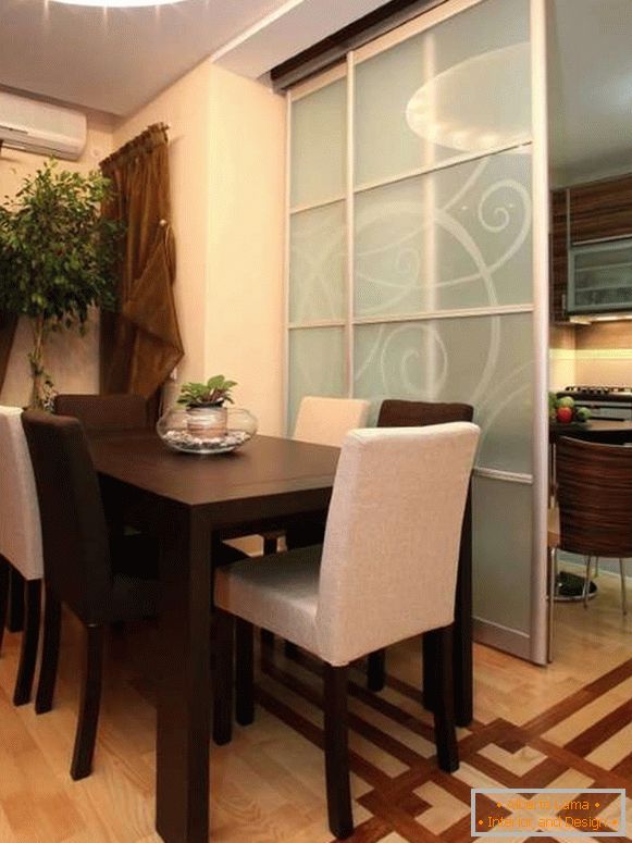 Compartimentele de sticlă între bucătărie și sufrageria într-o casă privată