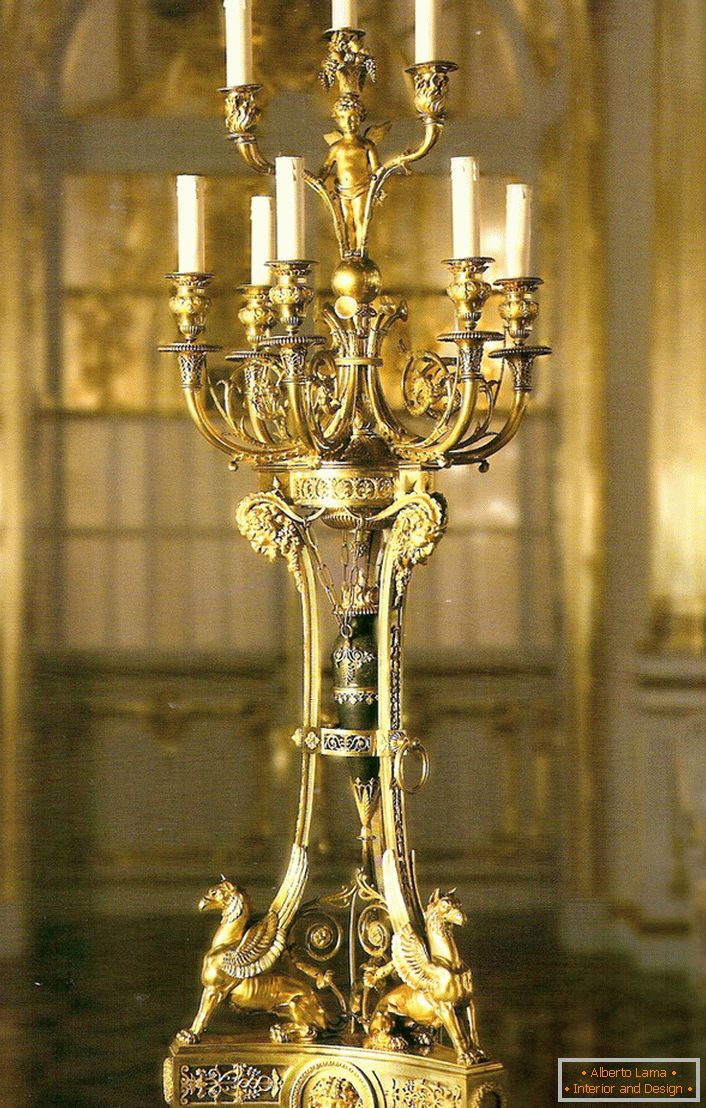 O candelabră de aur nobilă și rafinată pentru nouă lumânări va decora interiorul oricărei case de țară sau a unui cabană de vânătoare.