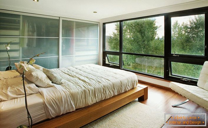 Un pat scăzut din lemn se potrivește armonios în interiorul dormitorului în stil Art Nouveau.