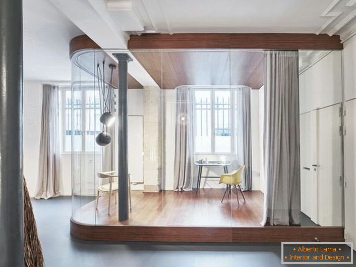 Biroul se află într-un apartament studio spațios. Stilul loft vă permite să selectați din punct de vedere organic zona de lucru.