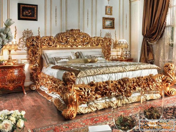 Un pat luxos este realizat în cele mai bune tradiții ale stilului Empire. Spatele masiv al unui pat de lemn sculptat de culoare nobilă de aur se ridică pe fundalul altor detalii ale interiorului.