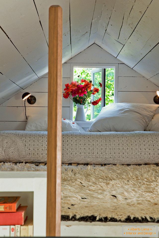 Dormitor sub tavan într-o mică casă confortabilă