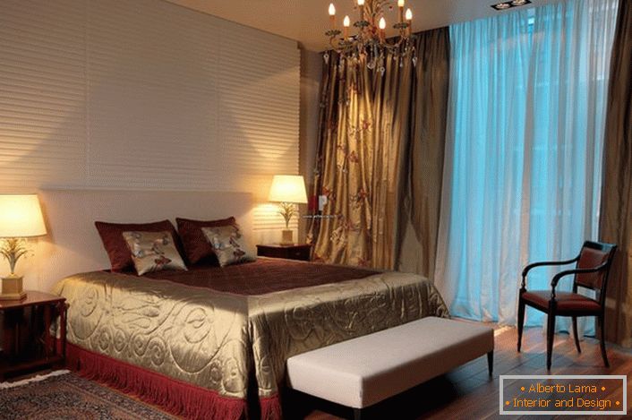 Iluminarea tradițională a unui sac de dormit într-un stil clasic-candelabru și plafoane obișnuite pe părțile laterale ale patului. 