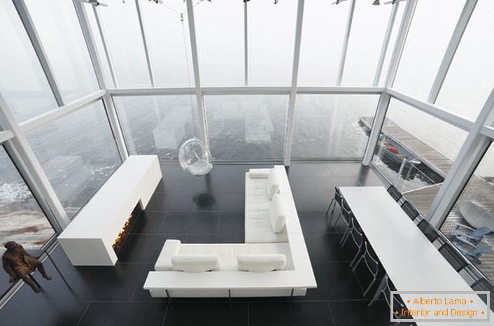 Designul laconic al livingului într-un stil minimalist. O piesă interesantă de mobilier este un scaun suspendat de un tavan înalt.