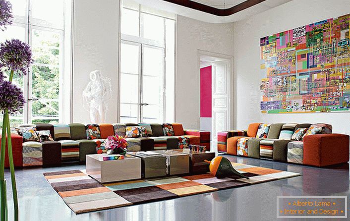 O cameră de oaspeți colorată în stil avangardist, într-o casă mare a unei familii italiene. Ideea de design combină în mod competent un covor și un mobilier cu o scară de culoare aproximativ identică.