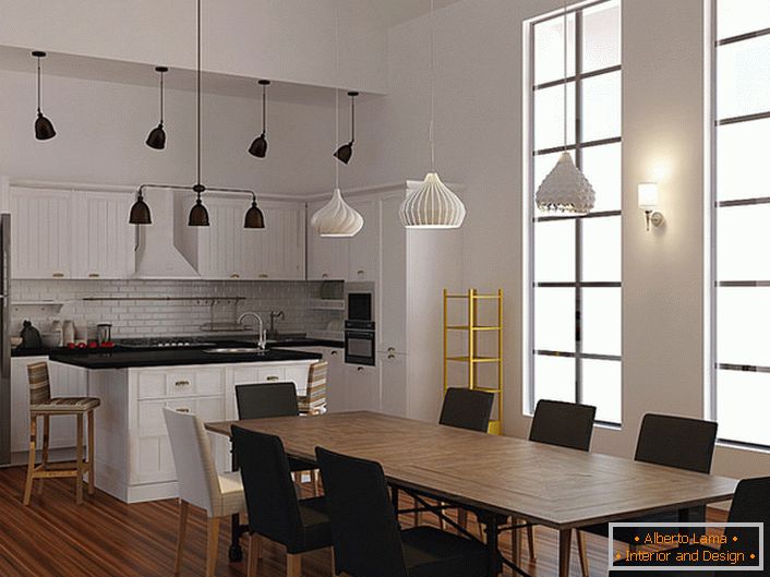 Un exemplu de iluminat bine ales pentru bucătărie în stil scandinav. Pentru a ilumina zonele de luat masa si de lucru, sunt folosite diferite modele de candelabre de tavan. 