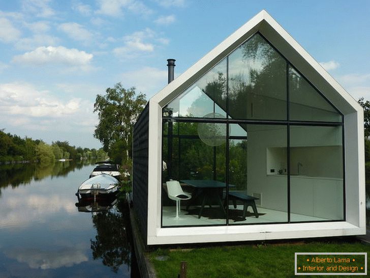 O mică casă de sticlă în apropierea lacului din Olanda