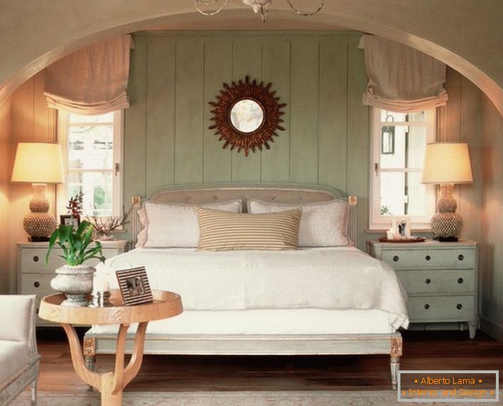 Dormitor de familie în stil țară. Căldura casei, pe cât posibil, este accentuată de un pat moale, volumetric, acoperit cu perne.