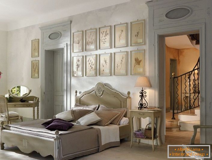 În conformitate cu tradițiile stilului francez pentru dormitor a fost selectat mobilier lemnos de lumină din lemn. Un detaliu interesant este un colaj de imagini deasupra capului patului.
