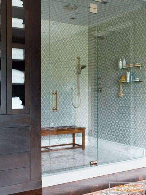 O ușă de sticlă frumoasă pentru un duș într-o nișă cu un gard