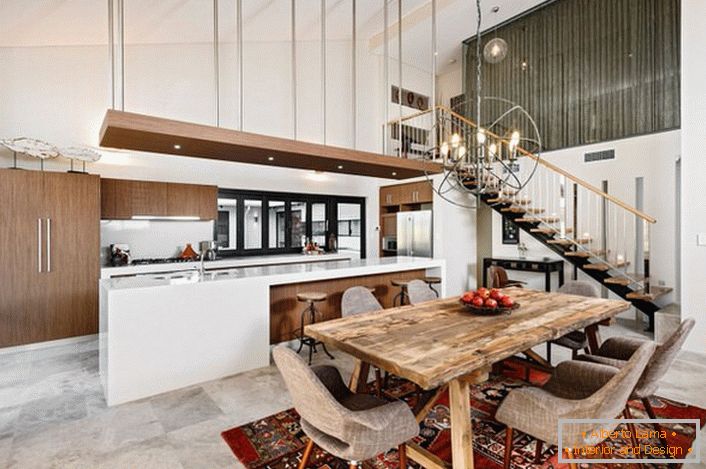 O bucătărie elegantă în stil loft nu este supraîncărcat cu detalii. Un set de bucătării funcțional și practic împarte spațiul într-o zonă de lucru și de luat masa.