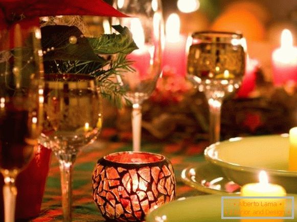 Ochelari și lumânări frumoase în decorul mesei de Anul Nou