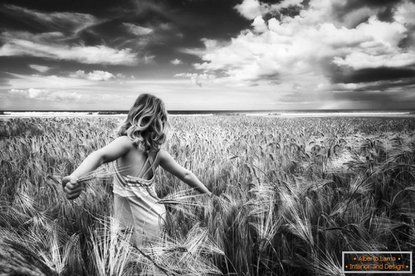 Fotografie alb-negru a unei fete într-un câmp de grâu