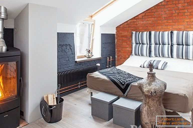 O sobă cu lemn de foc lângă pat