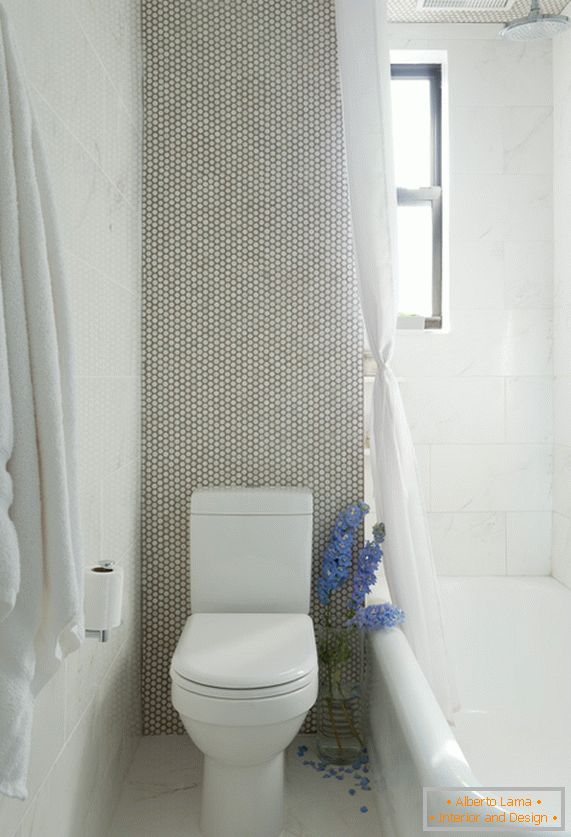 Un bol de toaletă albă și o baie în camera de marmură