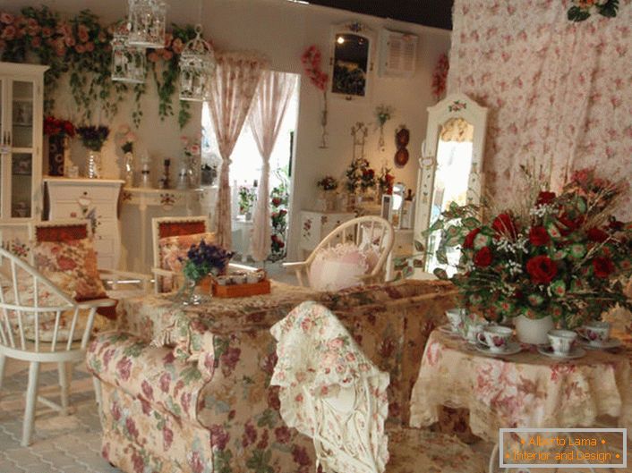Flori în vază, pe perete și chiar pe tapițeria canapelei. Sala în stilul Provence într-o casă mică de țară din sudul Franței.