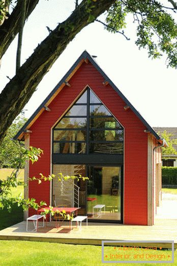 Interiorul unei case mici din lemn cu ferestre mari