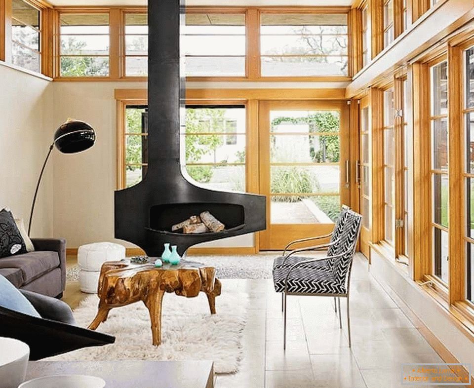 Designul livingului în casă cu șemineu și ferestre panoramice