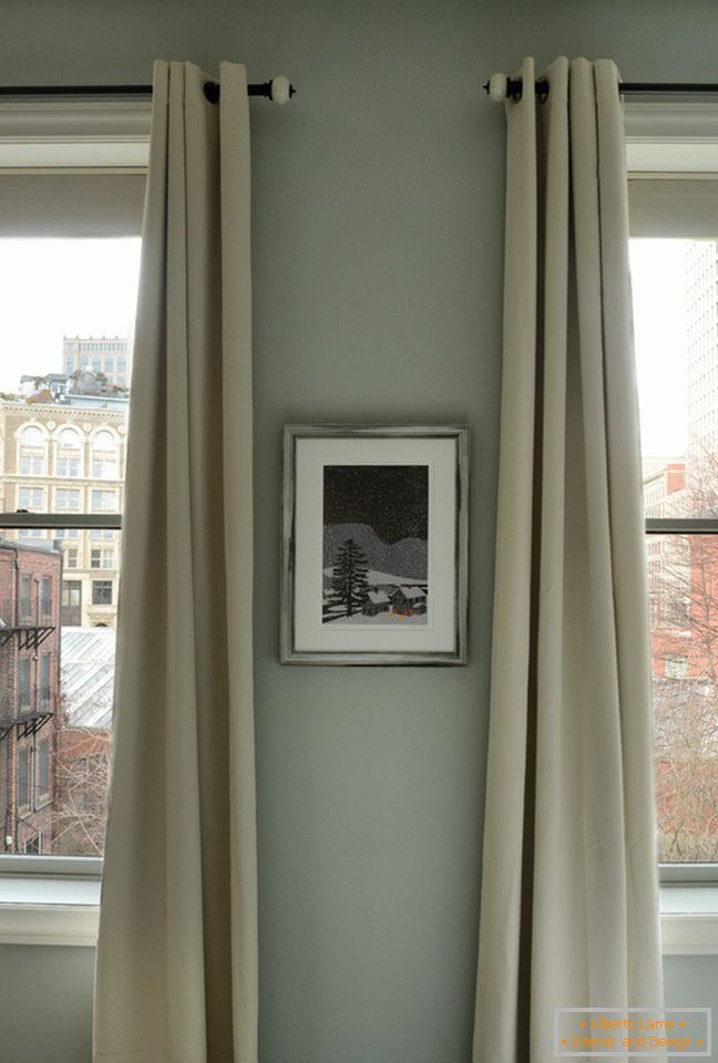 Interior al unui apartament mic: perdele lungi pe ferestre