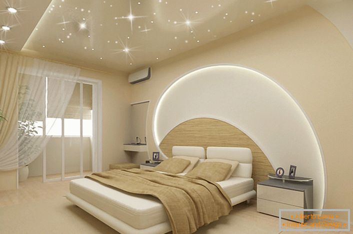 Atenția atrage decorarea pereților și tavanului în dormitor într-un stil modern. Dungile LED trec prin tavan, iar peretele de deasupra patului, plafoanele întinse imită cerul înstelat de magie.