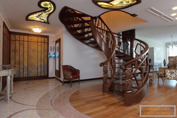 Sala în stil modern cu o scară spirală la etajul al doilea este dotată cu