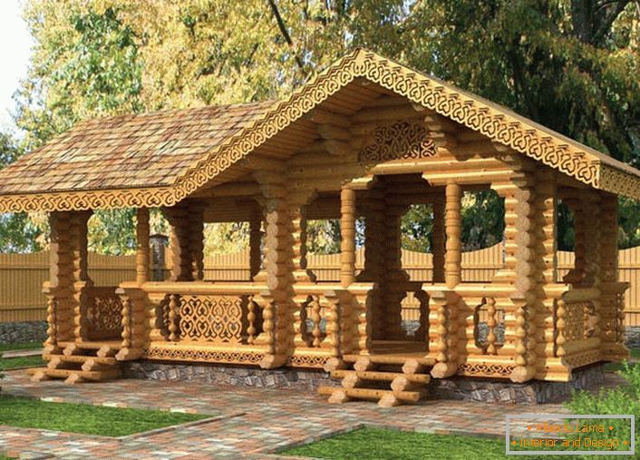 Un gazebo de basm în stilul unei cabane este construit dintr-un fascicul de lumină. La cabina de gazebo se conduc căile de dale de granit.
