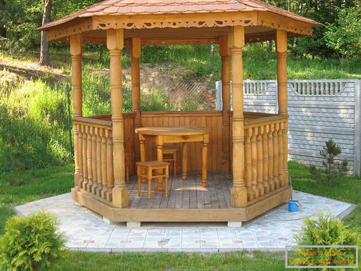 Stilul cabanei poate fi, de asemenea, elegant. Soluție funcțională - un podium mic pentru un foișor din plăci de granit.