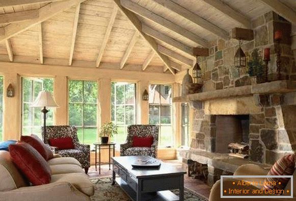 Interiorul halei cu șemineu într-o casă privată - un design de lemn și piatră