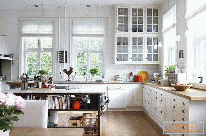 O bucătărie spațioasă în stil scandinav ar trebui să fie cât mai ușoară posibil. Se acordă prioritate lumina zilei, astfel încât bucătăria este echipată cu ferestre mari cu rame din lemn. 