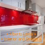 Mobilier alb și un șorț roșu în interiorul bucătăriei