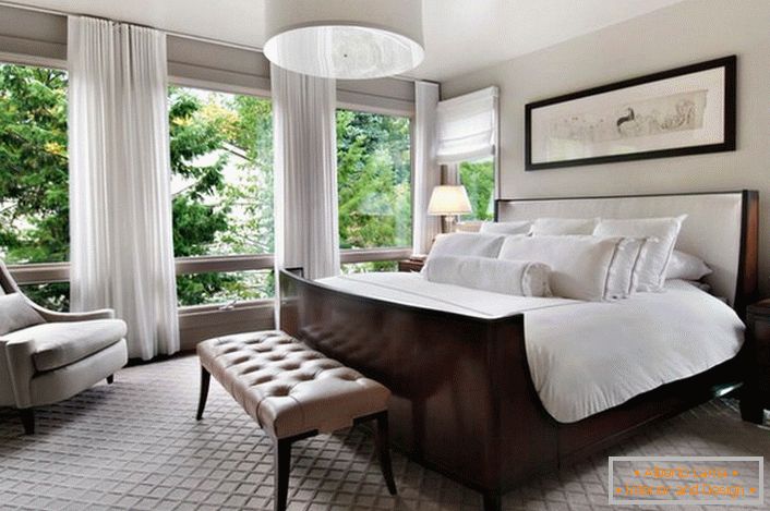 Dormitor luxos într-o casă de țară. Vedere uimitoare de la fereastră până la peretele complet.