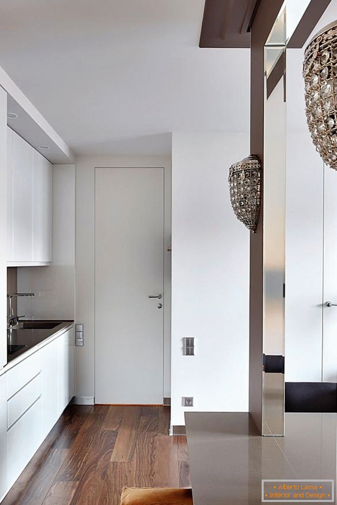 Mobilier de bucătărie alb, ușă de intrare albă și parchet frumos din lemn