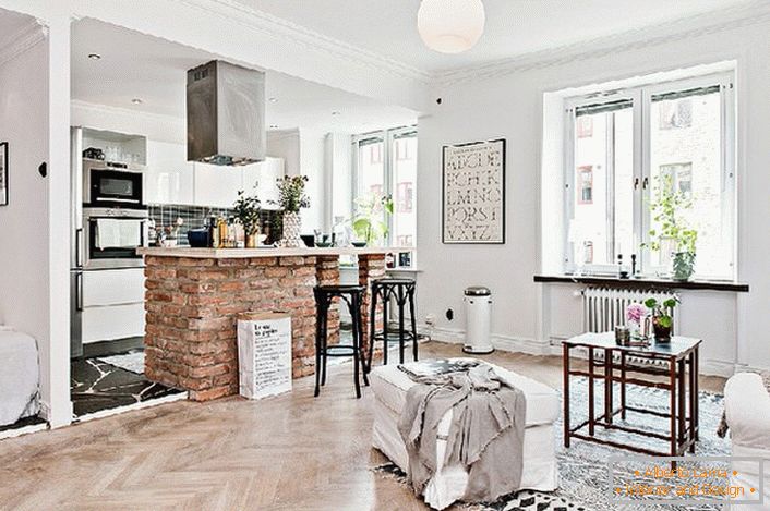 Apartamentul studio este decorat în stil scandinav. Bucătăria este separată de camera de zi de un contor de bârne din cărămidă.
