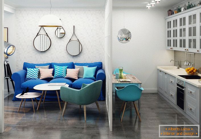 Canapea albastru închis contrastează cu finisajul luminos. Un exemplu de design reușit al unui mic apartament cu o cameră.