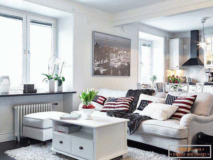 Un apartament confortabil în stil scandinav este decorat în principal în alb. Ferestrele fără perdele permit suficientă lumină naturală pentru a intra în cameră.
