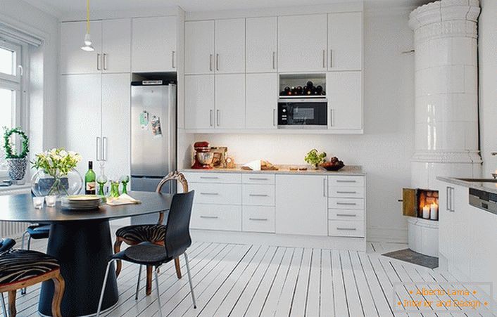 Șemineu din șemineu, realizat din plăci ceramice albe, se potrivește organic în interiorul bucătăriei în stil scandinav.