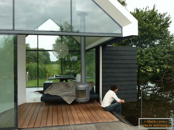 Terasa unei case mici de sticlă lângă lac din Olanda