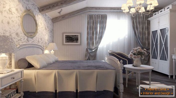 Dormitorul în stilul țării este realizat în tonuri albastre silențioase. Zidul de la capul patului este acoperit cu tapet cu un model floral.