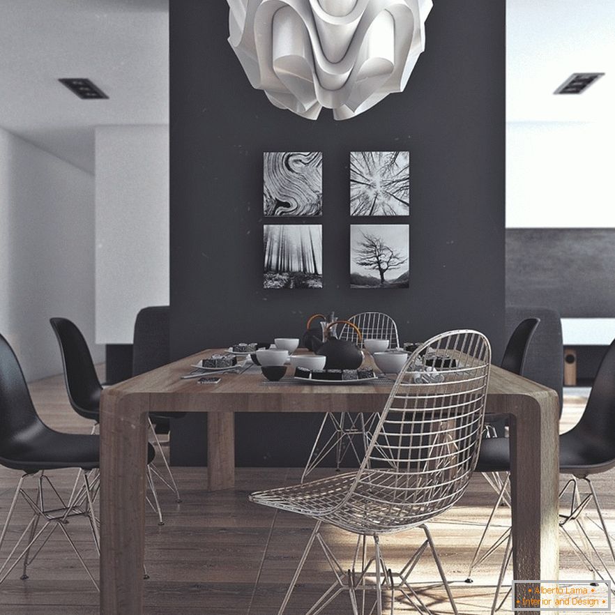 O masă din lemn, scaune negre și picturi originale pe un perete negru