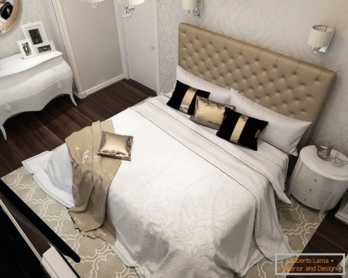 În centrul compoziției de proiectare se află un pat cu un material tapițat moale, tapițat. Stilul pompotic artă-deco se manifestă prin folosirea de țesături scumpe pentru decor, așadar pe pat se văd perne cu perne de satin și lenjerie de pat chic.