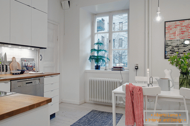 Bucătărie cu zonă de luat masa a unui mic apartament în stil scandinav